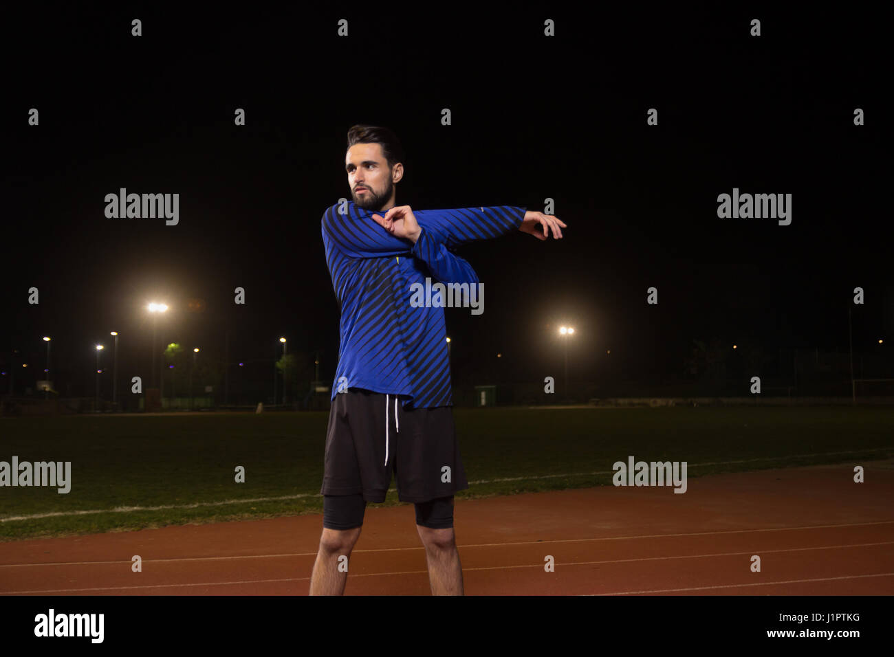 Young adult man, athlete, soccer football player, stretching upper body