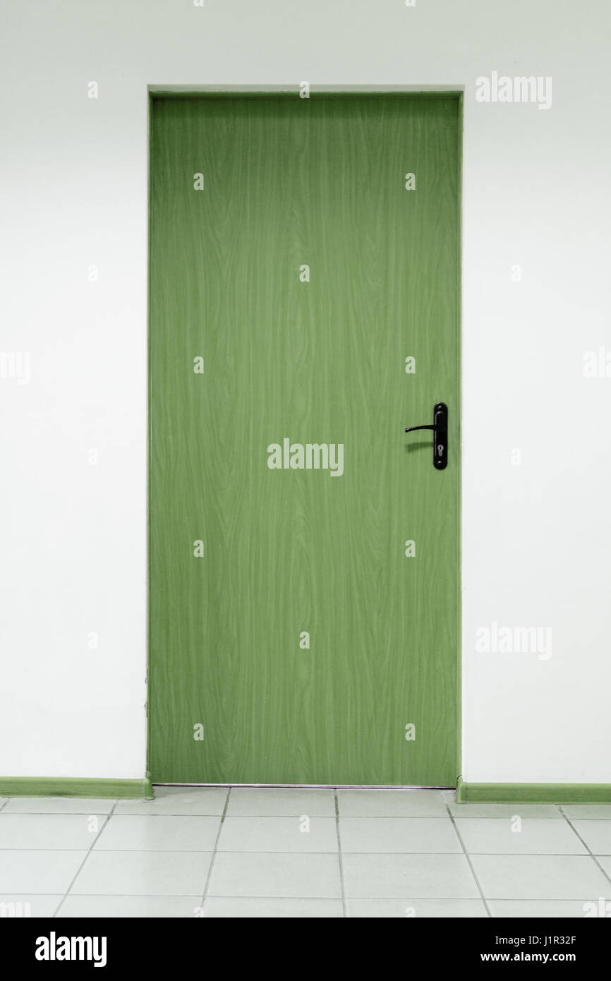 Wooden door on a clean wall indoors Stock Photo