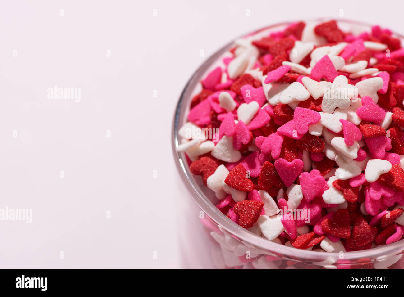 Valentines Day Glass with lots of sweet candy hearts Stock Photo