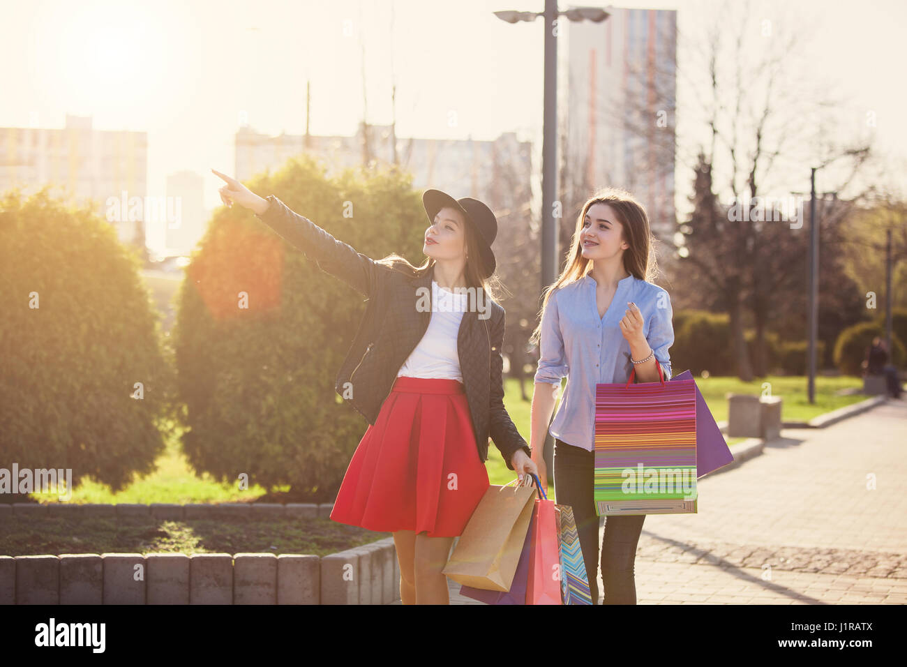 Two girls walking with shopping on city streets Stock Photo - Alamy