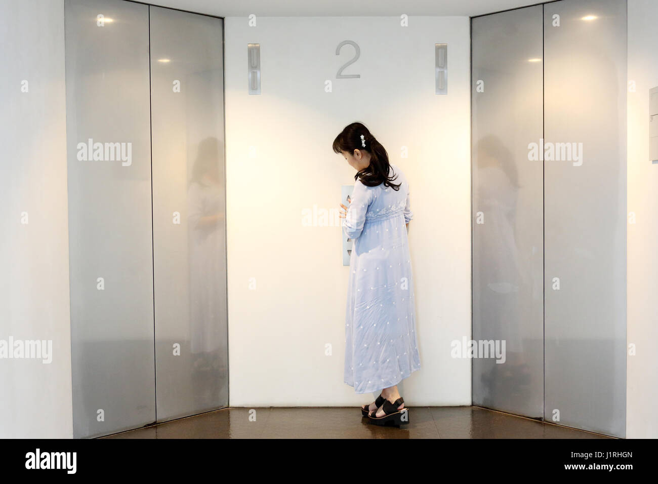 modern metal elevator doors with woman in a hall Stock Photo