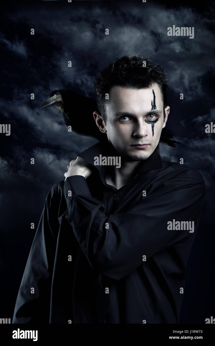 Spooky man with crow on his shoulder Stock Photo - Alamy