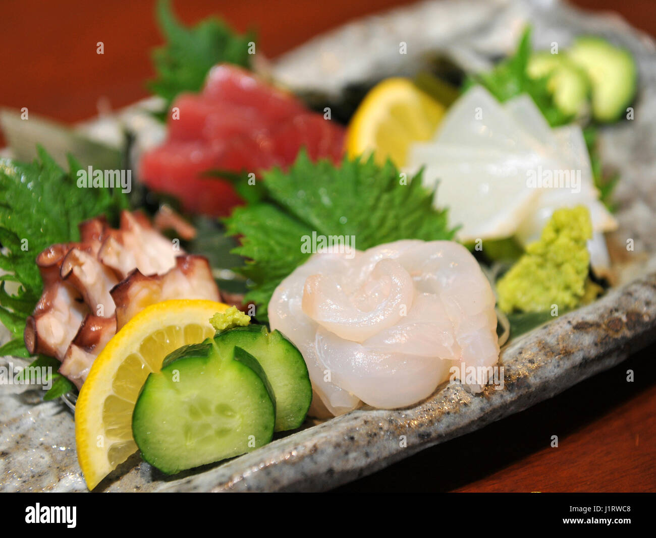 Fresh sashimi of fugu fish with cucumber, lemon and wasabi Stock Photo