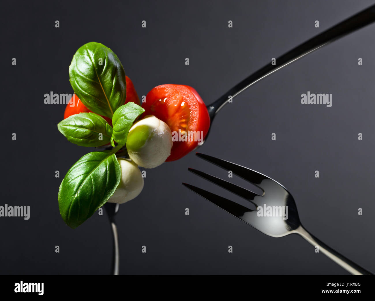 Mini mozzarella cheese with tomato cherry and green basil leaves on a