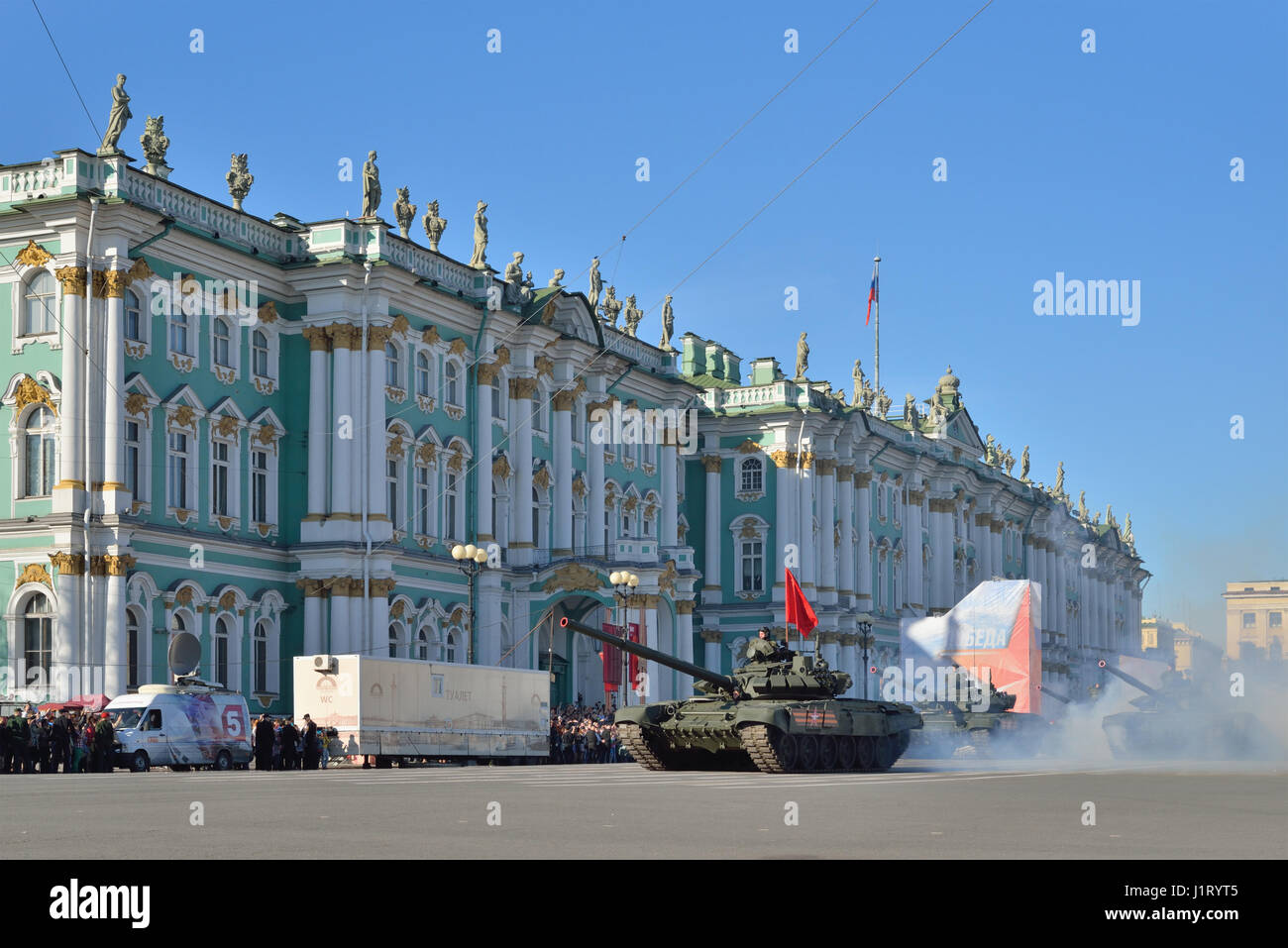 ST.PETERSBURG, RUSSIA - MAY 05, 2016:  Tanks T-90 with a red flag in a puff of smoke at the Palace square during a rehearsal of the Victory Parade  in Stock Photo