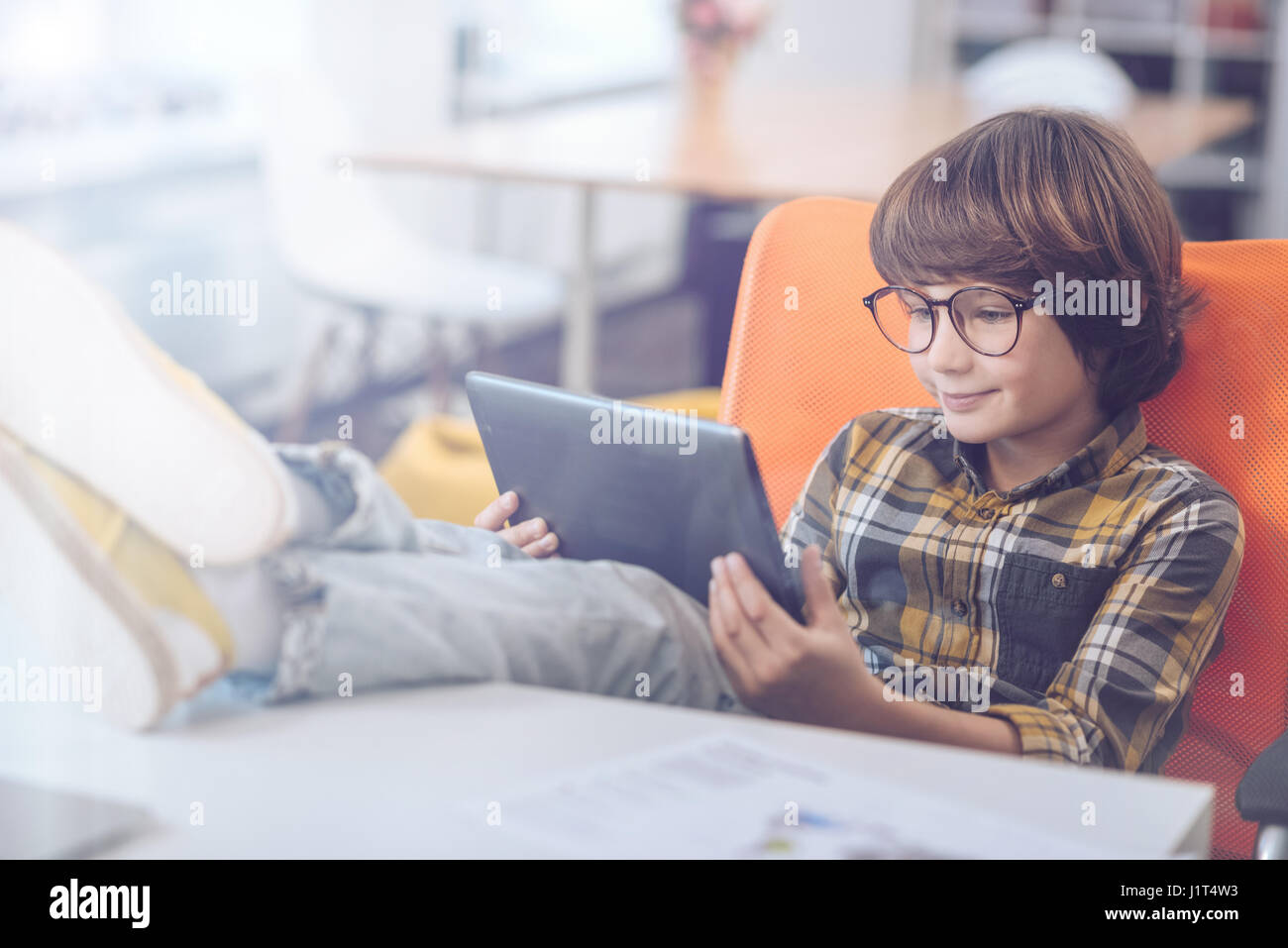 Boy using digital tablet with feet up Stock Photo