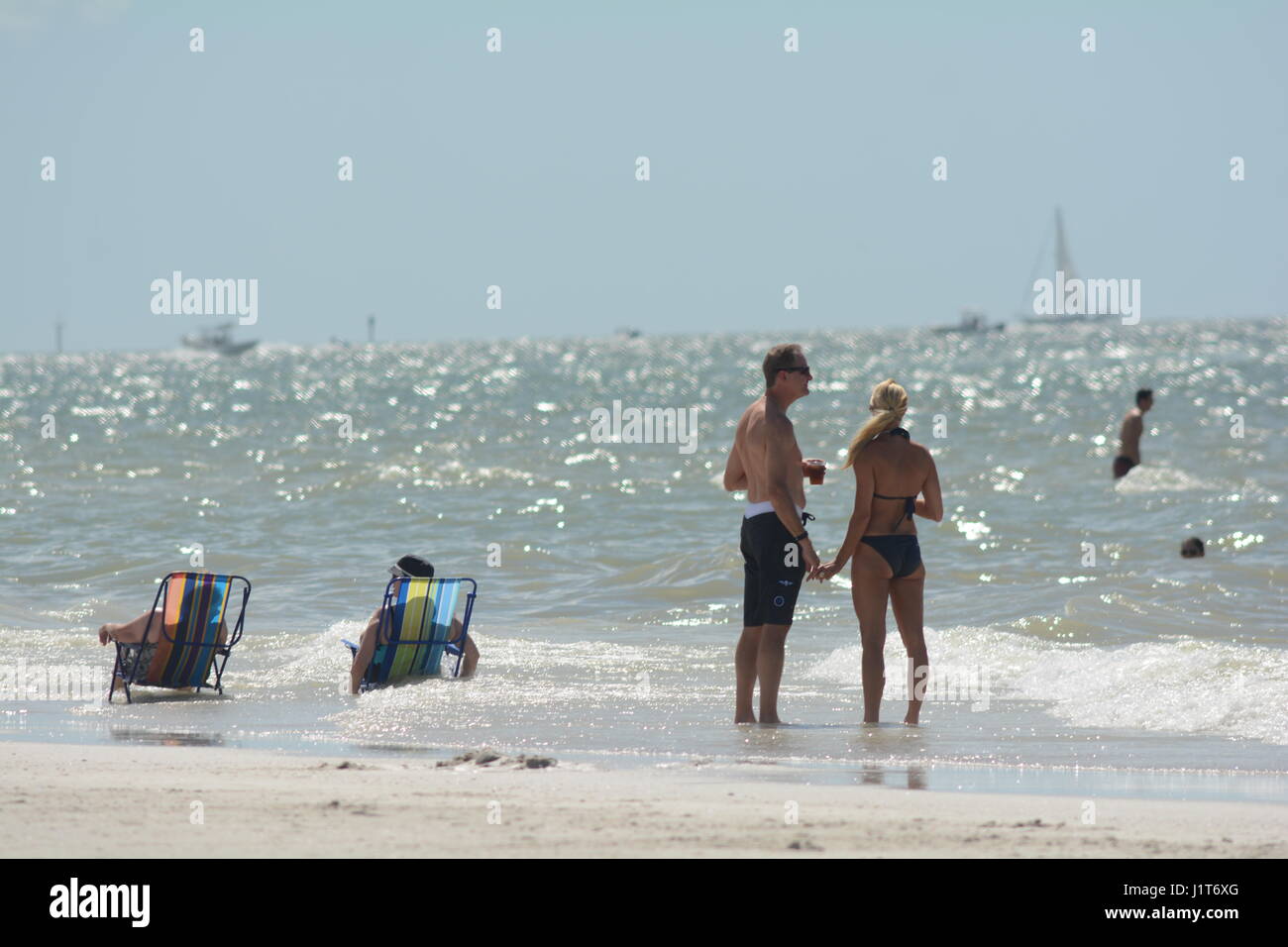 people at the beach and in the ocean in Florida Stock Photo