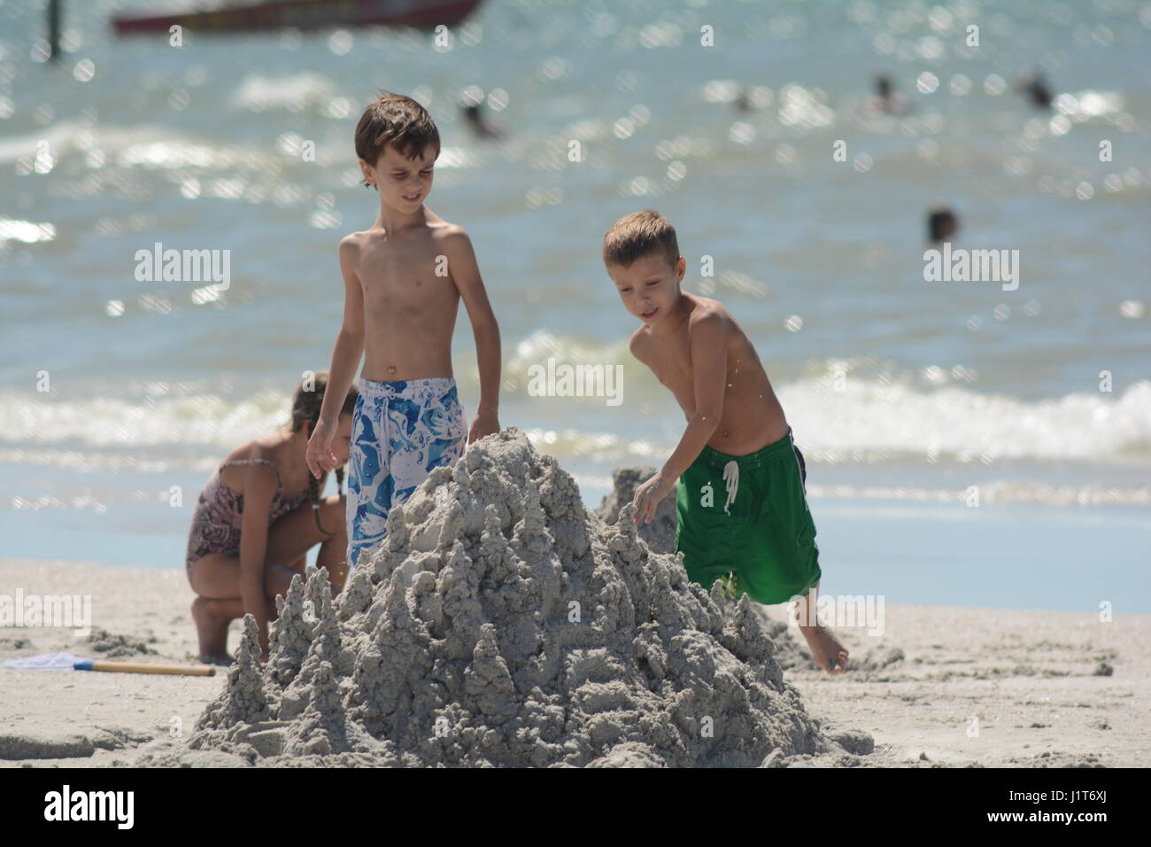 people at the beach and in the ocean in Florida  kids making sand castle Stock Photo