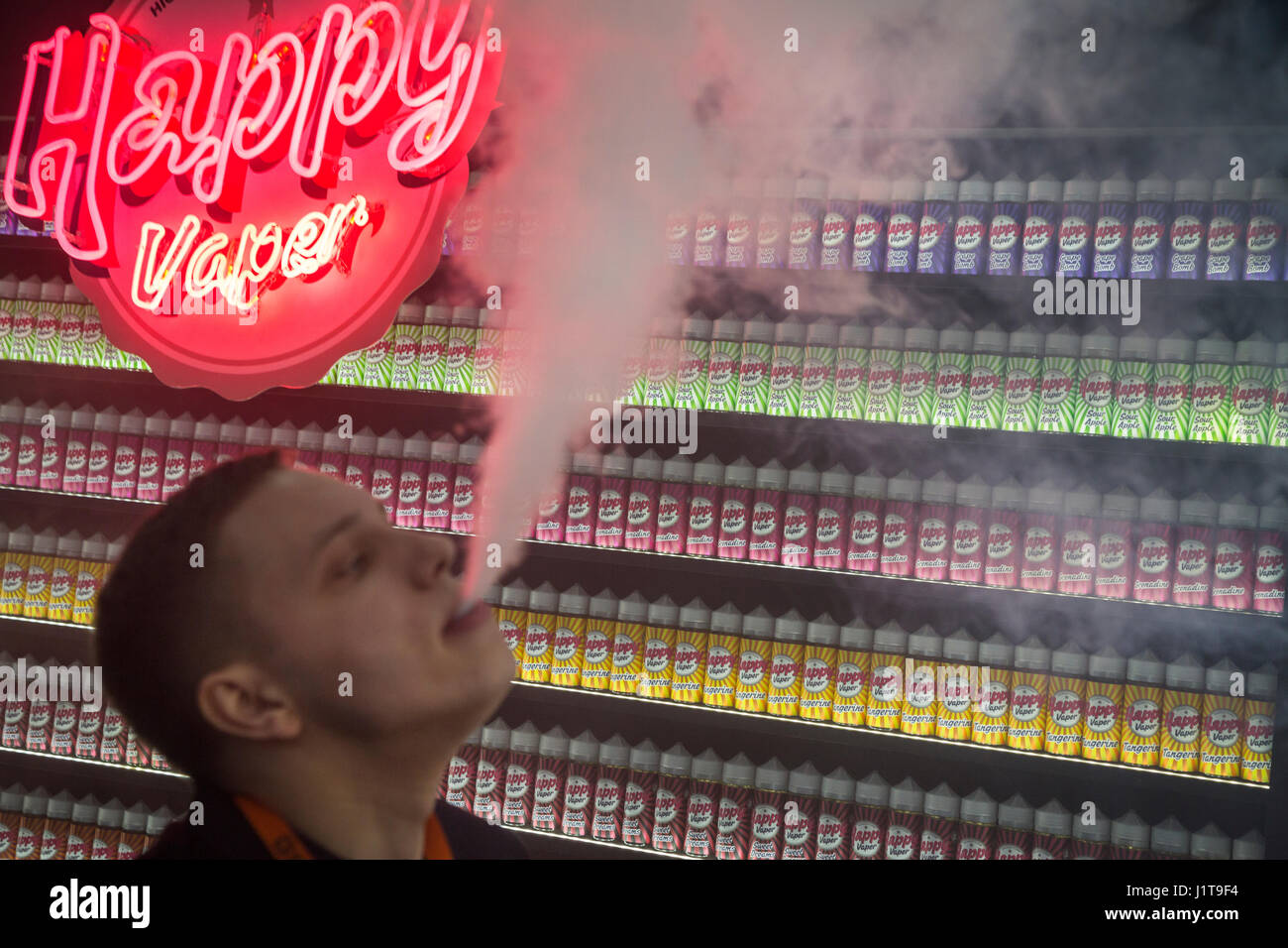 A man smokes electronic cigarettes in a vape shop Stock Photo