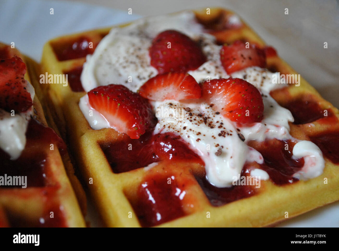 Delicious homemade waffles with whipped cream, jam, cocoa and