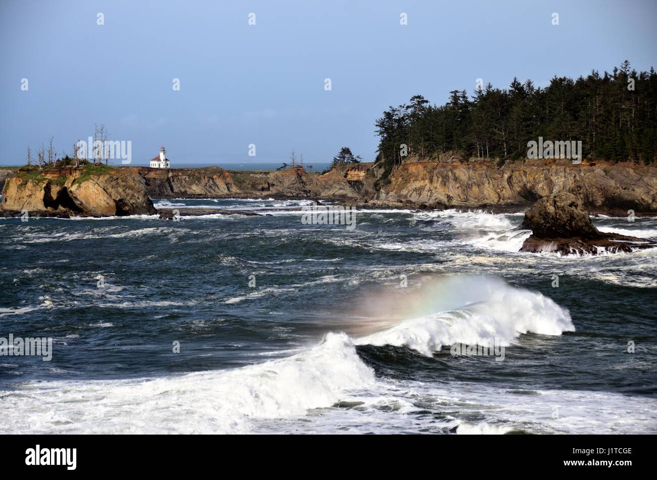 Cape Arago Lighthouse with Rainbow Wave, Coos County, Oregon Stock Photo
