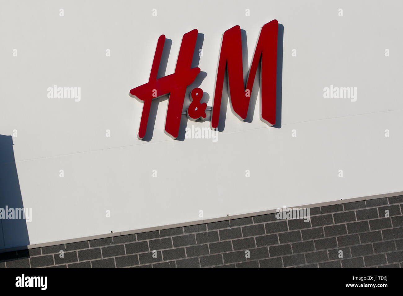 A logo sign outside of a Hennes & Mauritz (H & M) retail store in ...