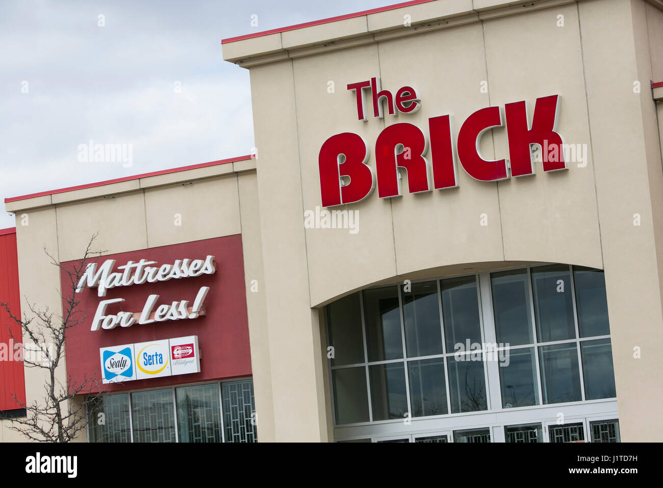A logo sign outside of a The Brick retail store in Mississauga, Ontario