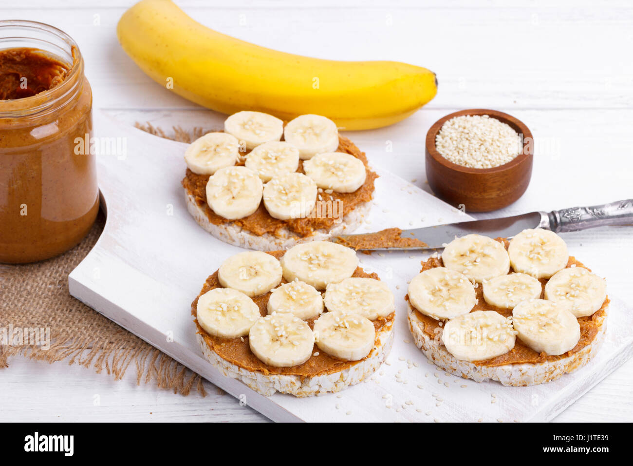 Rice cakes with peanut butter and slices of banana and sesame seeds on