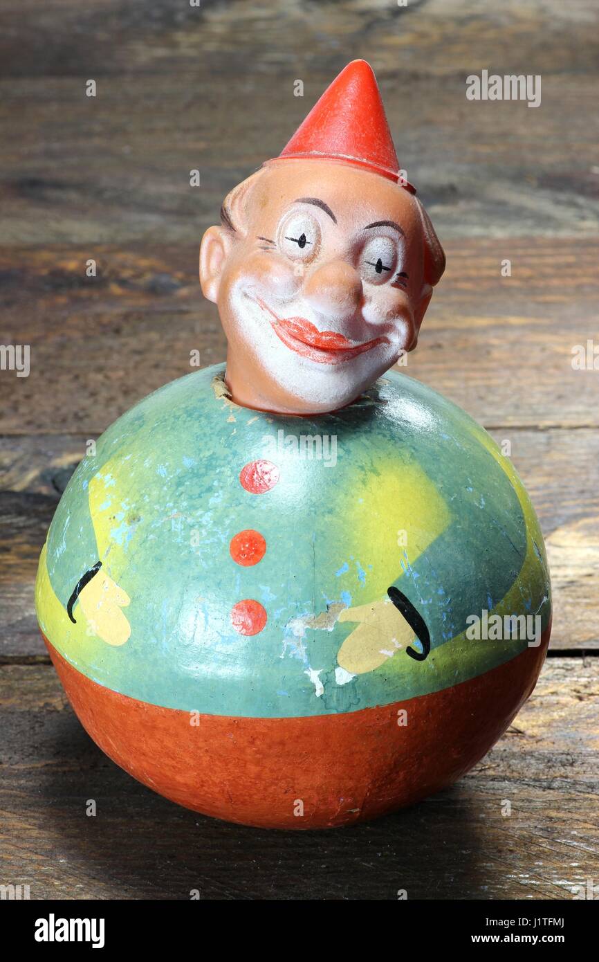 antique roly-poly doll on wooden background Stock Photo