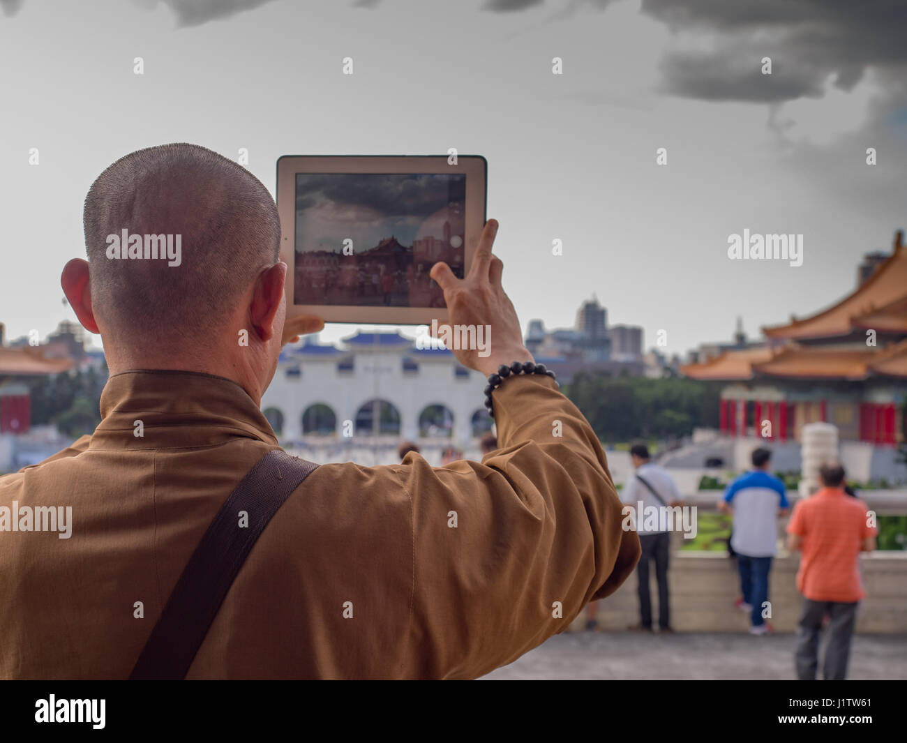Taipei, Taiwan - October 02, 2016: Buddhist monk takes a picture with his iPad on the  Liberty Square in Taipei Stock Photo