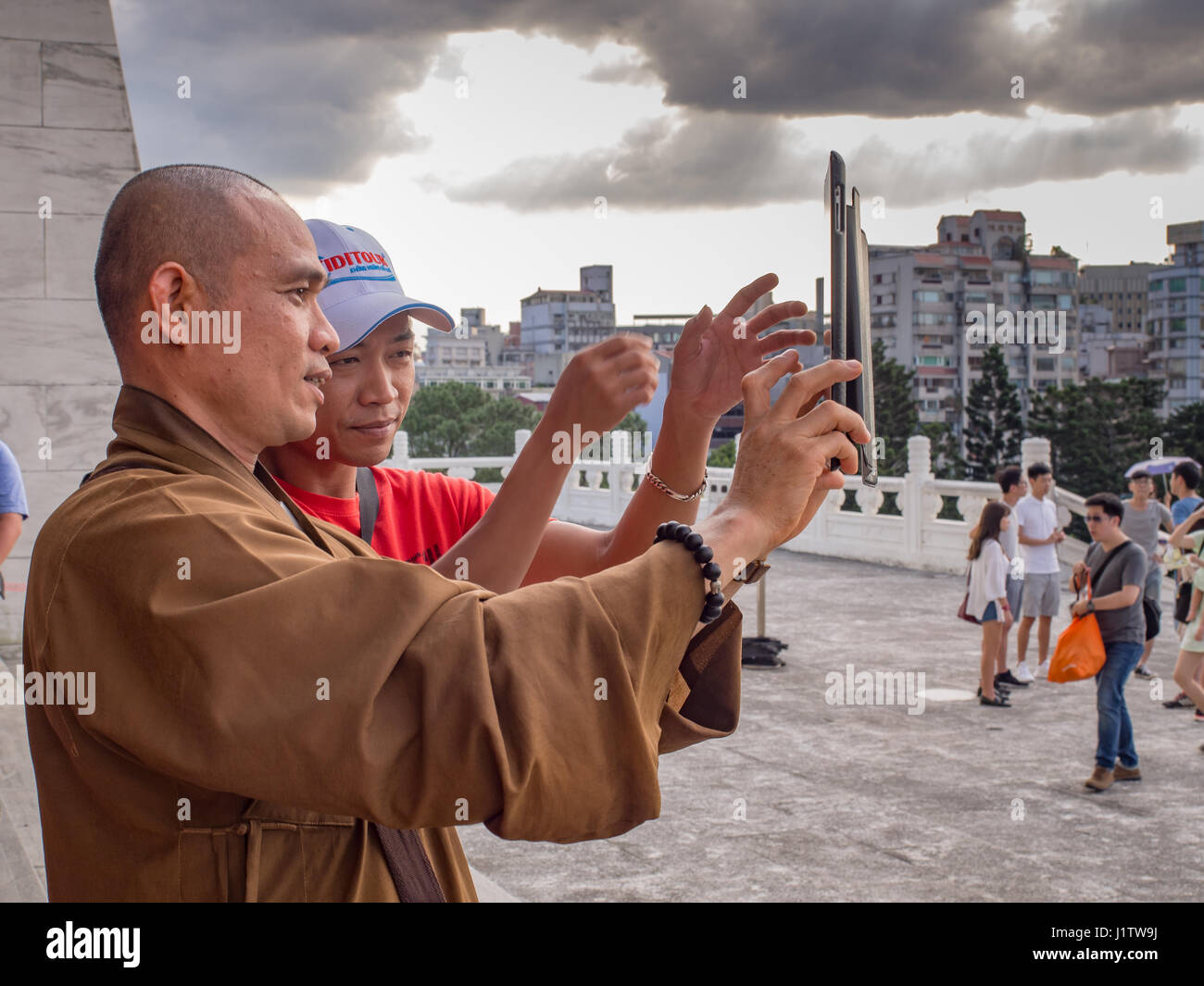 Taipei, Taiwan - October 02, 2016: Buddhist monk takes a picture with his iPad on the  Liberty Square in Taipei Stock Photo