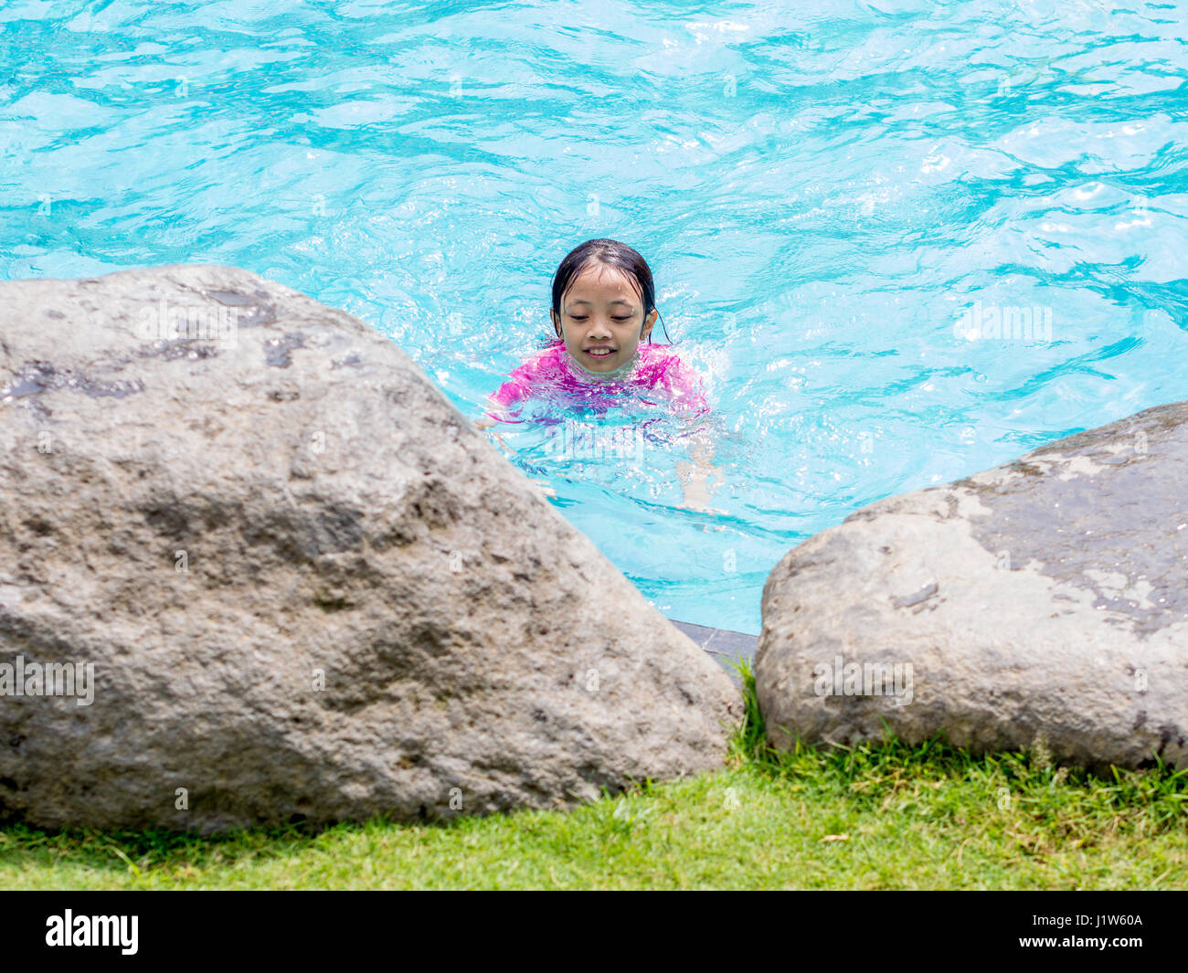 Asian Kid (Girl) in Swimming Pool with Finger Pointing Stock Photo - Alamy