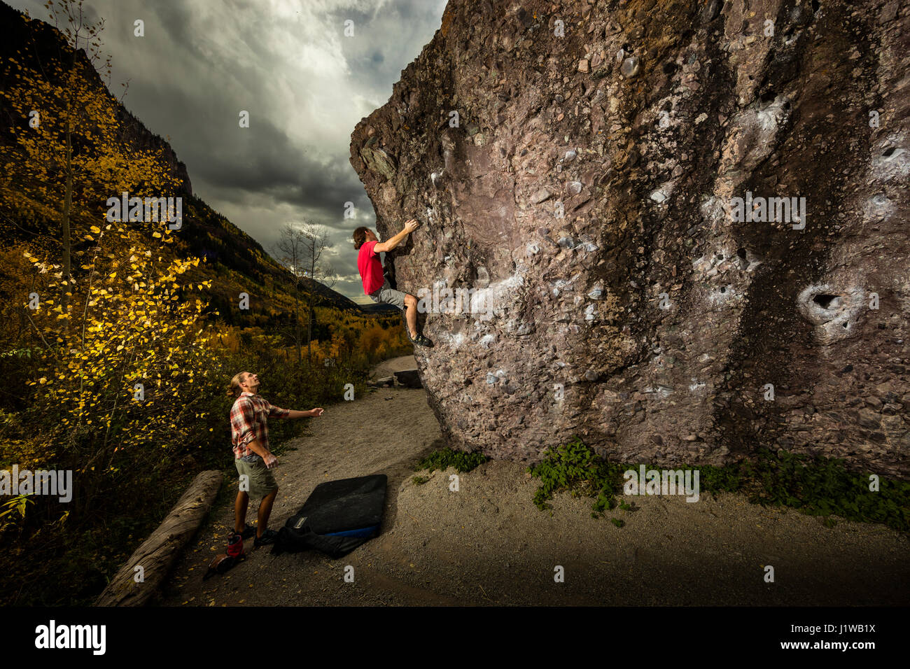 Andrew Merrill spotting Chris Brock bouldering at the Mine boulders near Telluride, CO. Stock Photo