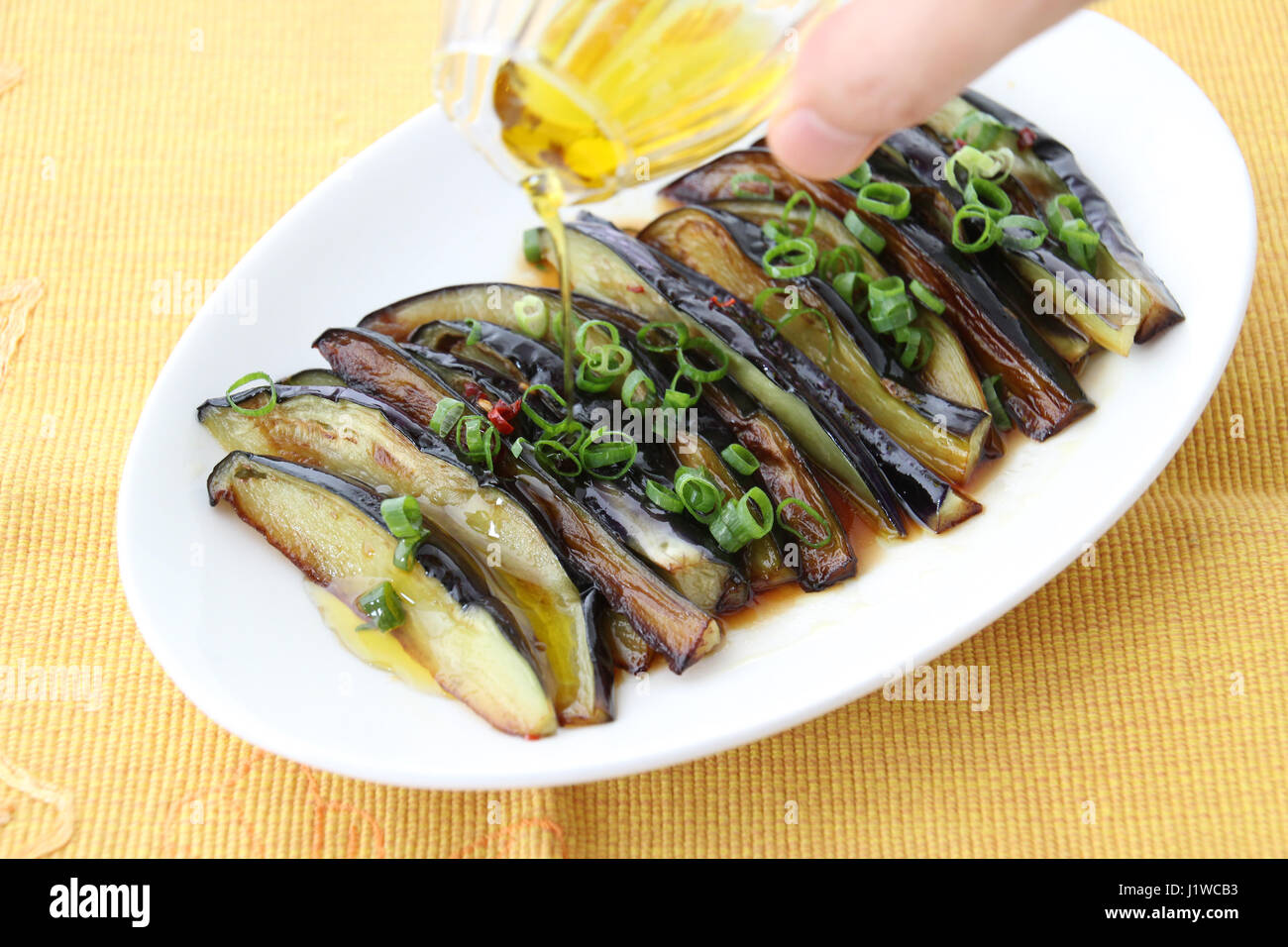 Grilled eggplants with oil and onion on white platter Stock Photo Alamy