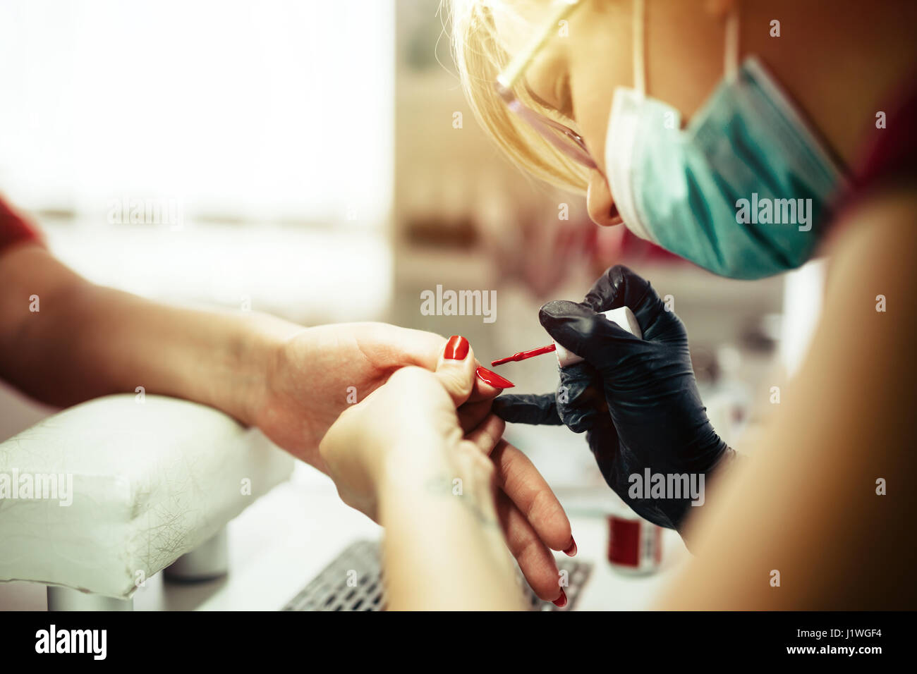 Woman at beauty salon receiving manicure and nail treatment Stock Photo