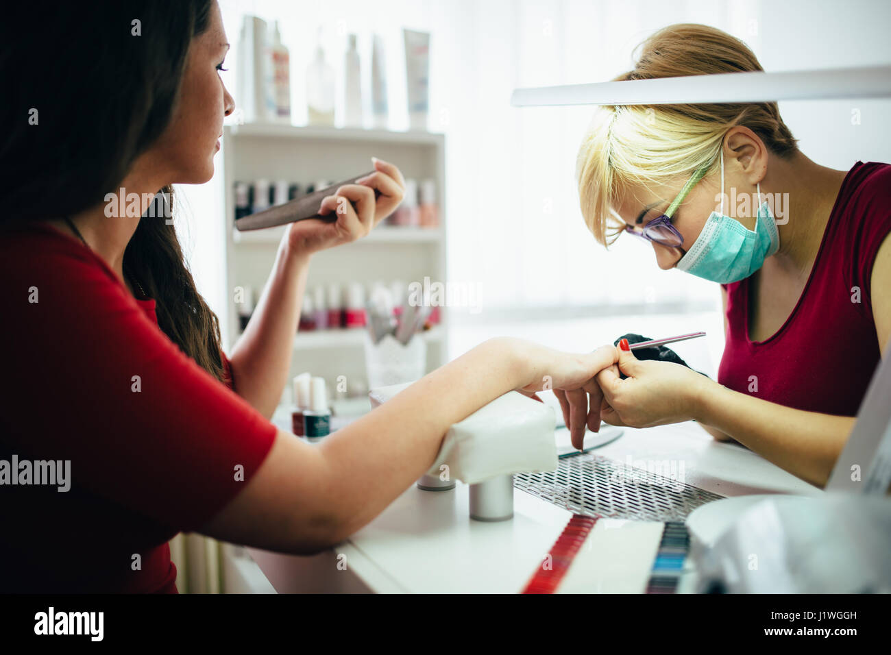 Woman at beauty salon receiving manicure and nail treatment Stock Photo