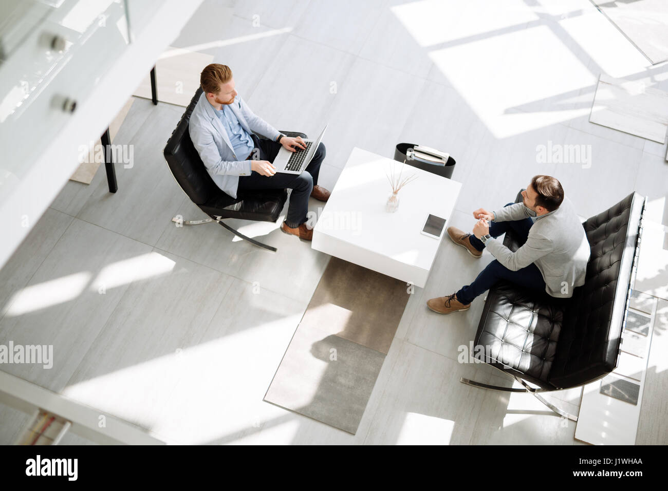 Business people discussing ideas in office lobby Stock Photo