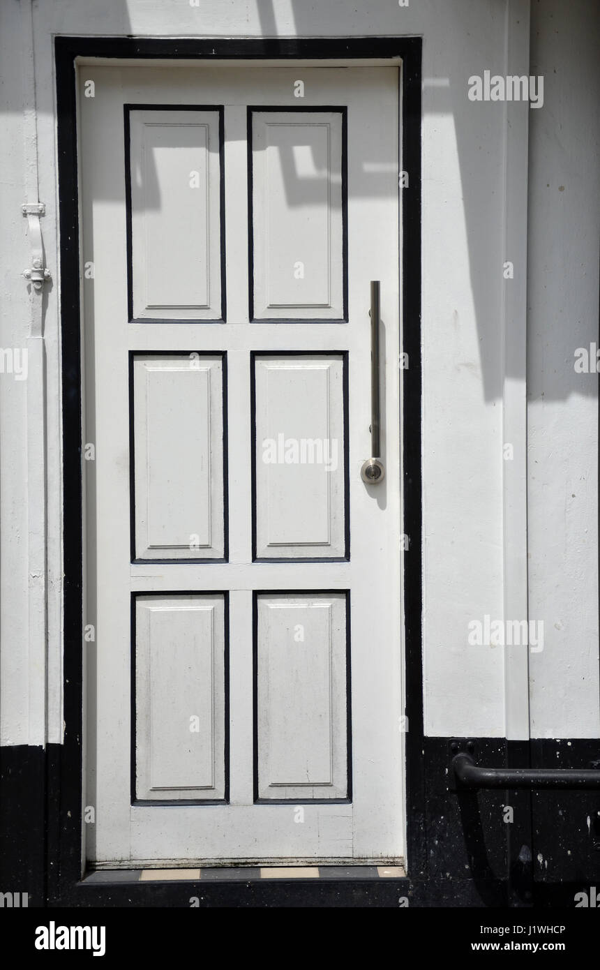 White wall with white door with black frame Stock Photo - Alamy