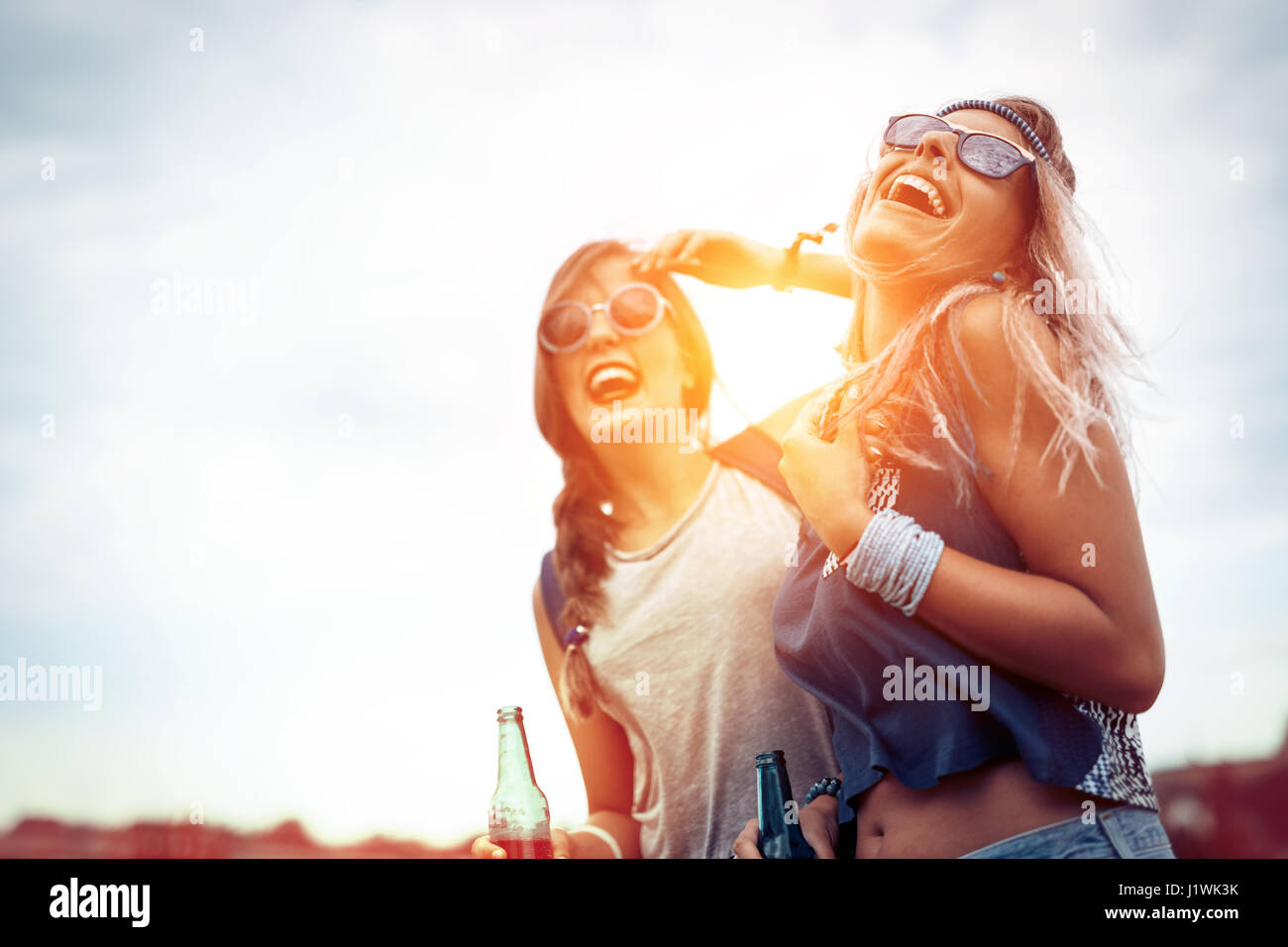 Happy friends laughing and having fun outdoors at concert Stock Photo