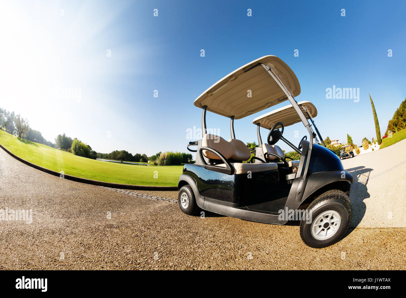 Closeup picture of two golfcarts standing at the car park in summer
