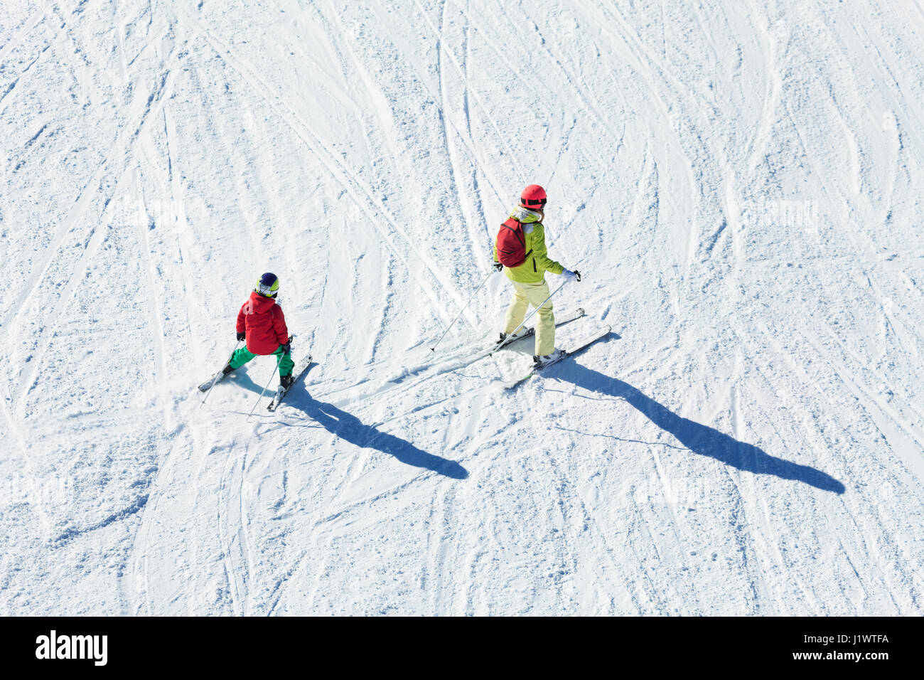 Top view portrait of active woman and her kid son skiing at snow-capped mountains Stock Photo