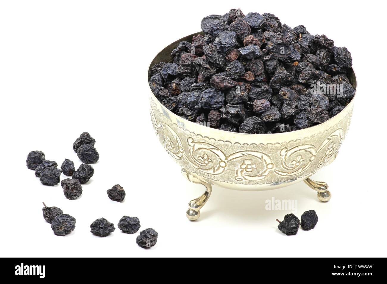 dried aronia berries in a silver bowl isolated on white background Stock Photo