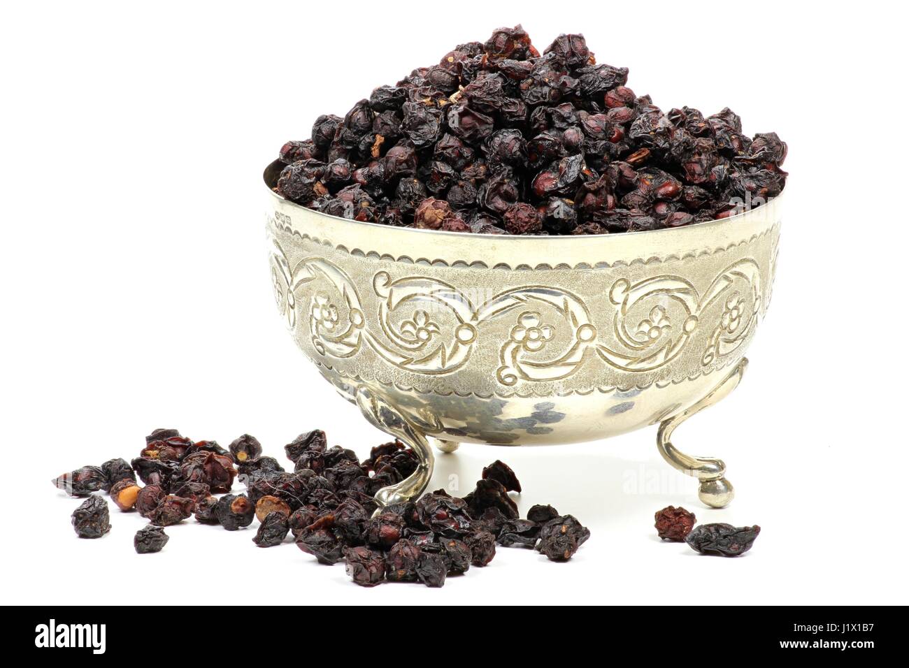 dried schisandra berries in a silver bowl isolated on white background