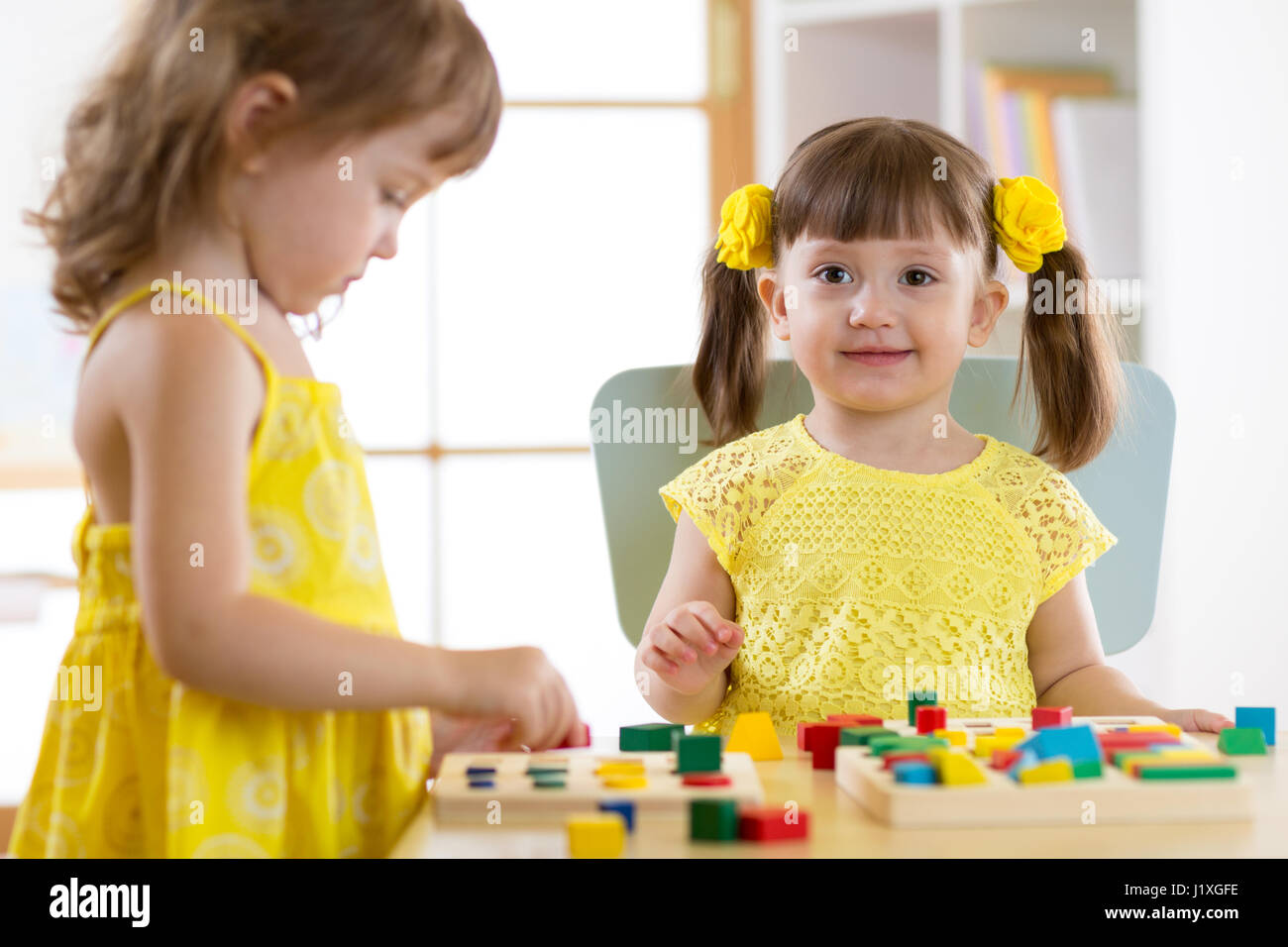 children learning to sort shapes in kindergarten or daycare center Stock Photo