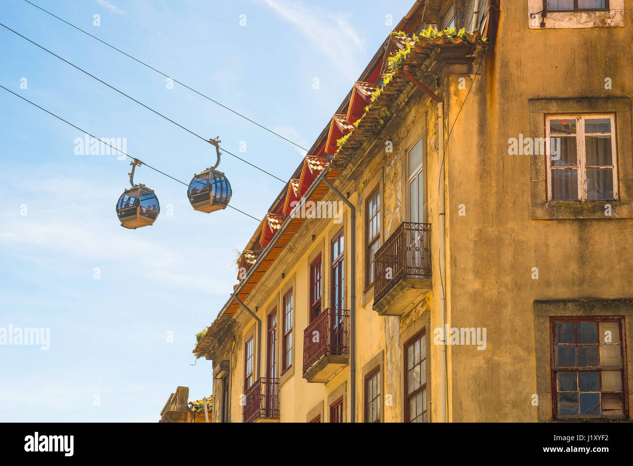 Gaia cable car, view of a pair of cable cars carrying tourists high above the streets of the Gaia district in the city of Porto, Oporto, Portugal Stock Photo