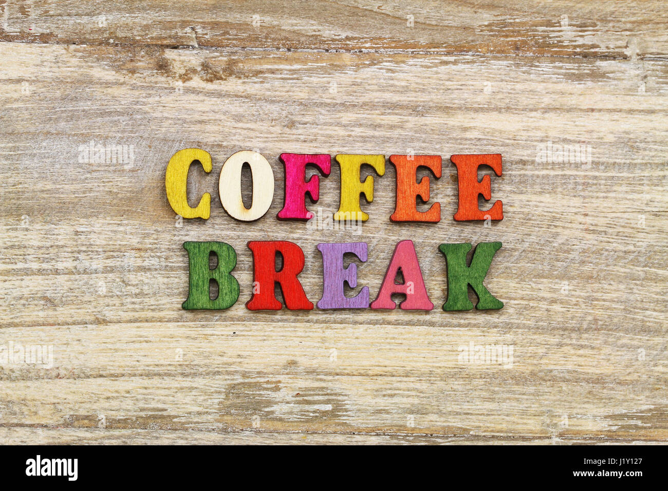 Coffee break written with colorful letters on rustic wooden surface Stock Photo