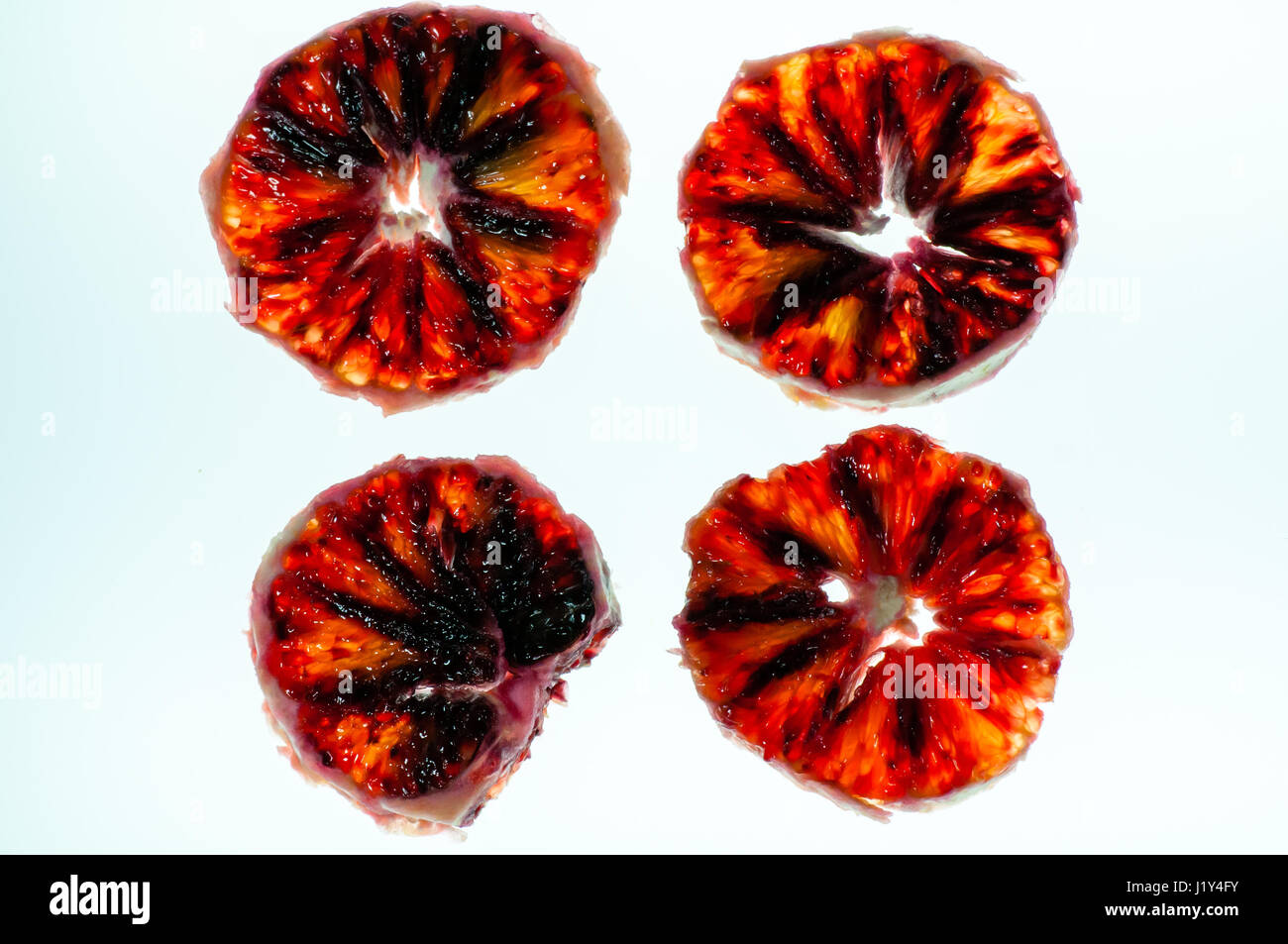 Peeled, slices of blood orange, against lightbox, close-up Stock Photo