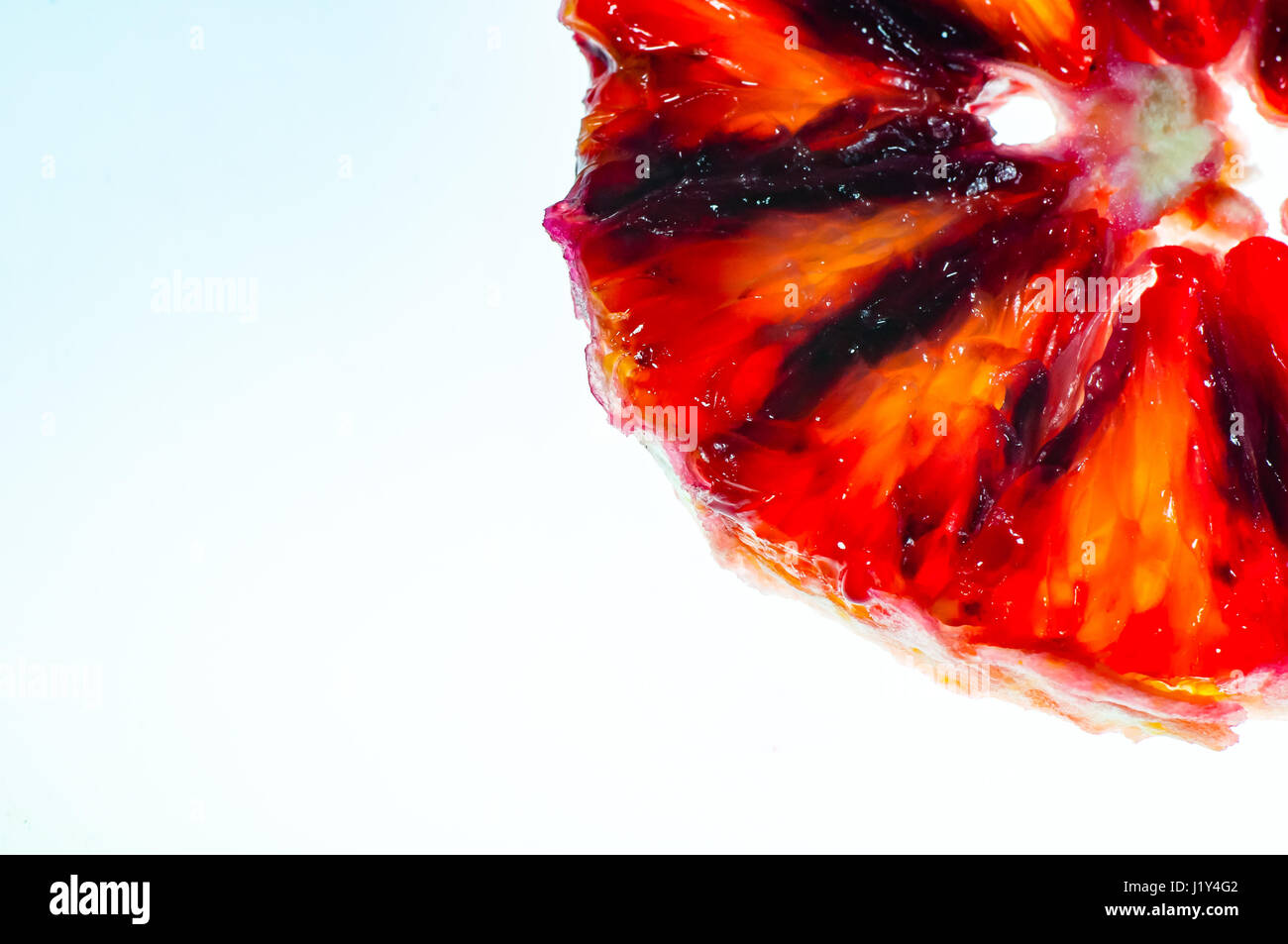 Peeled, slice of blood orange, against lightbox, close-up Stock Photo