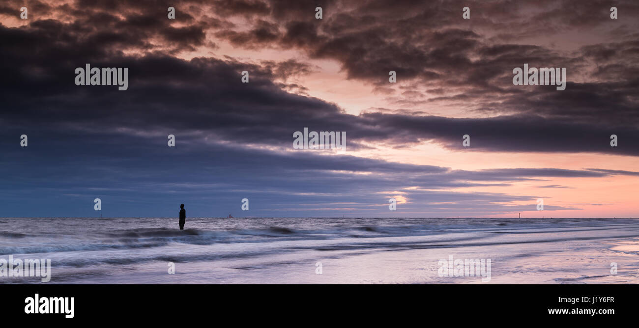The colourful light reflects on the tide at Crosby beach