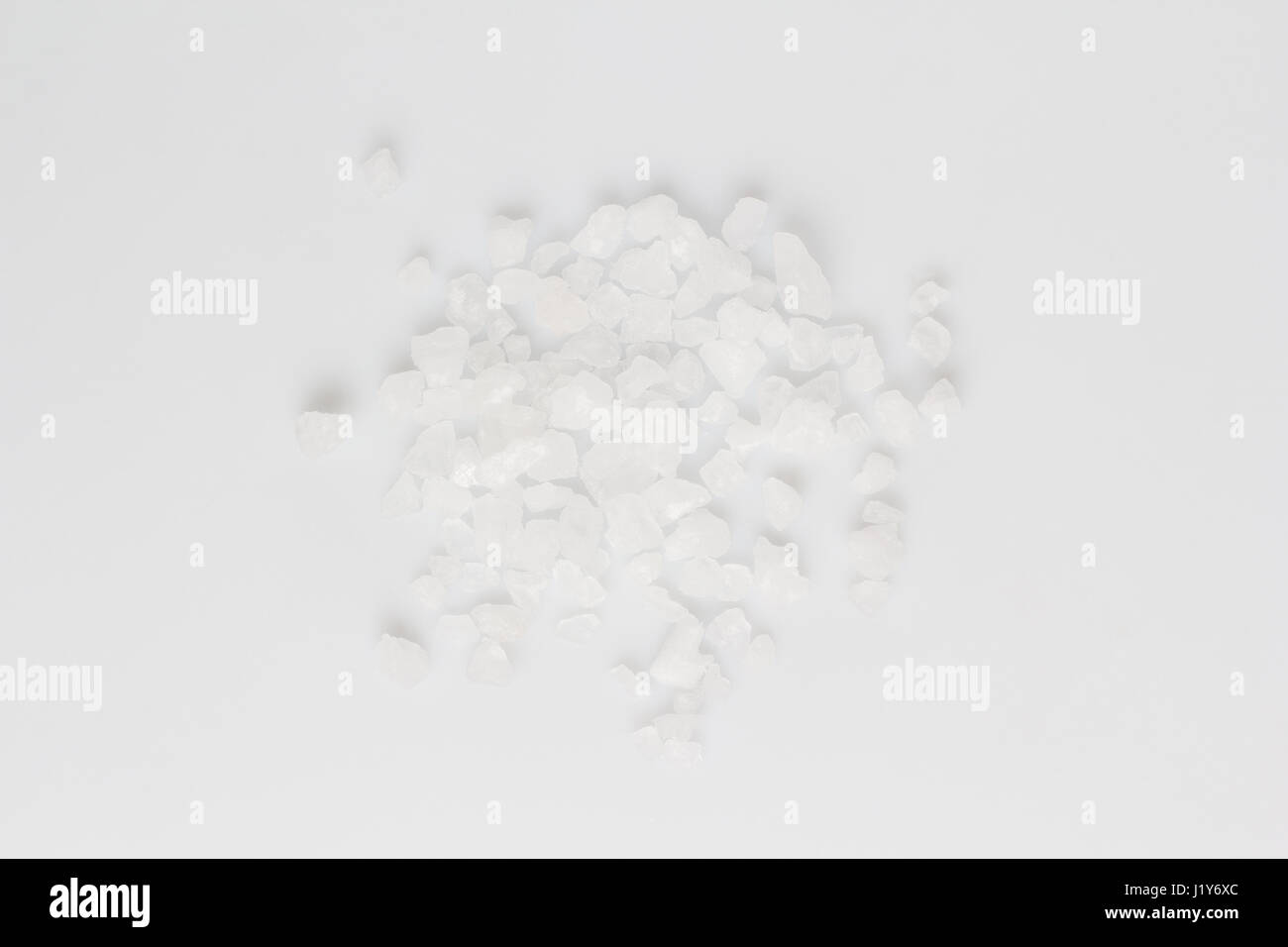 A scattering of sea salt on a white background Stock Photo - Alamy