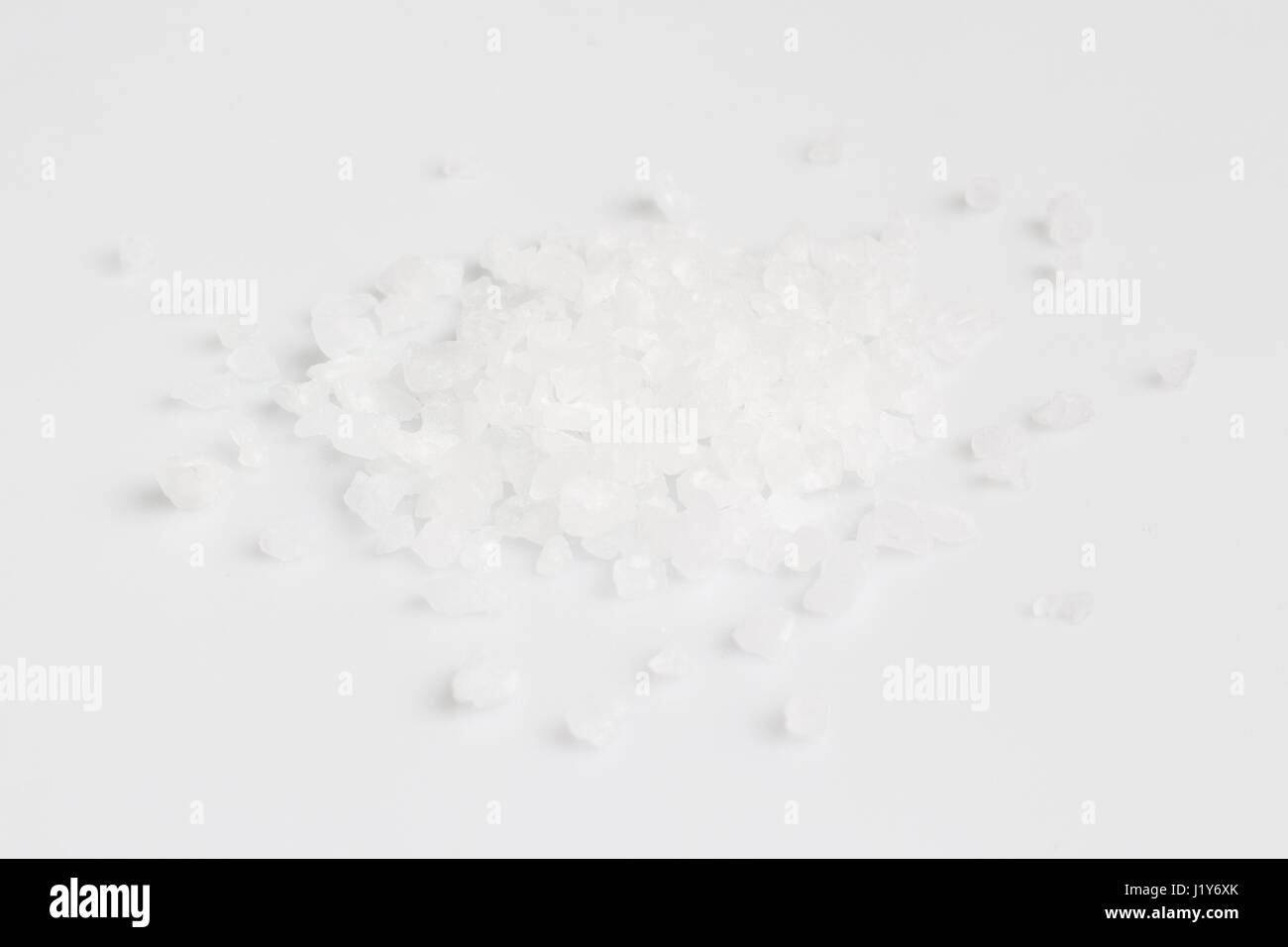 A scattering of sea salt on a white background Stock Photo - Alamy