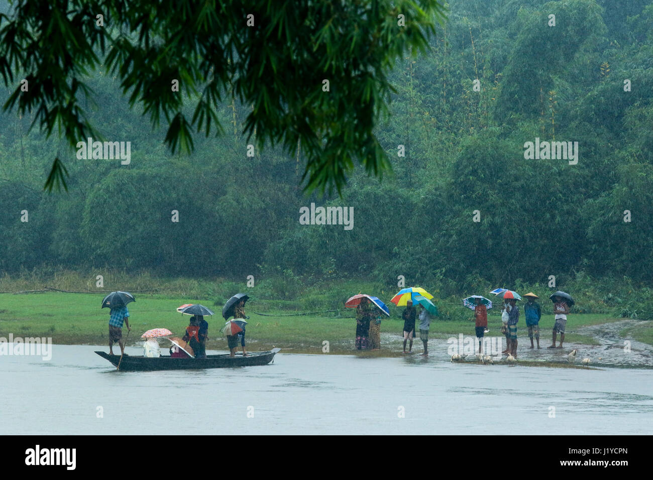 Passengers wait for getting up on the boat at the Piain Riverbank during the rainfalls at Gowainghat. Sylhet, Bangladesh. Stock Photo