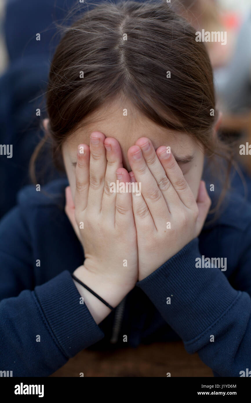 Young girl covering her face and her eyes with her hands Stock Photo ...