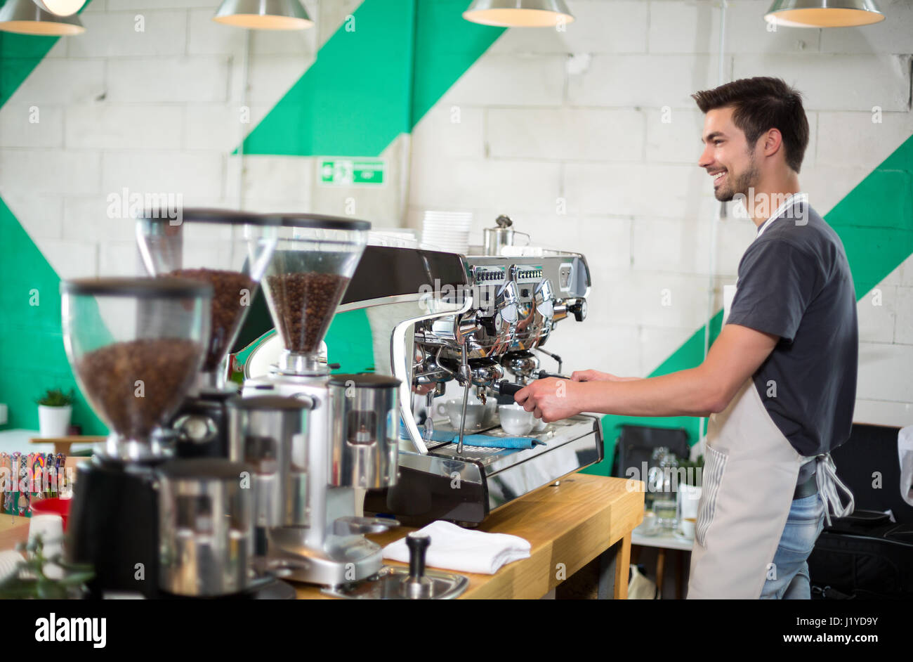 Handsome male barista making coffee and serving coffee Stock Photo