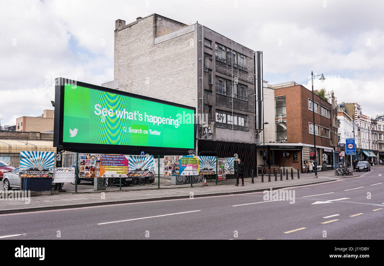Shoreditch High Street view with big digital billboard showing an add of the social network company Twitter Stock Photo