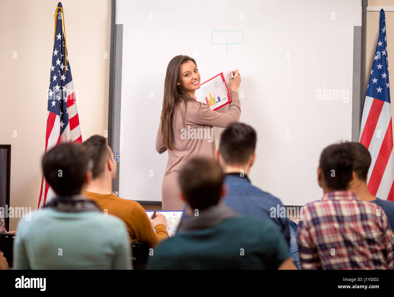 Young lecturer demonstrate diagram on blackboard for her students Stock Photo