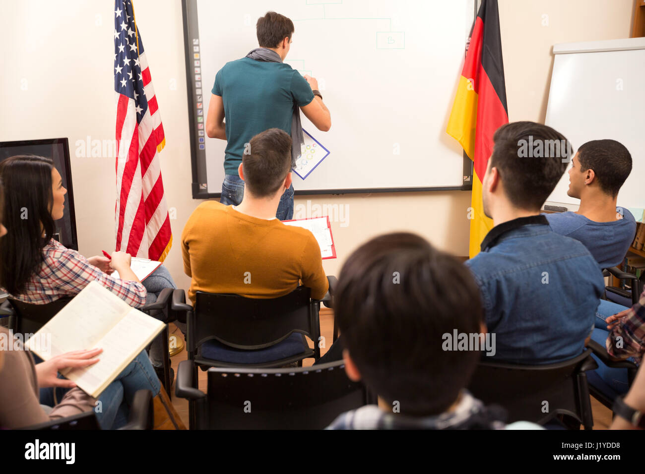 Handsome male lecturer doing task in front of his students  on the blackboard Stock Photo