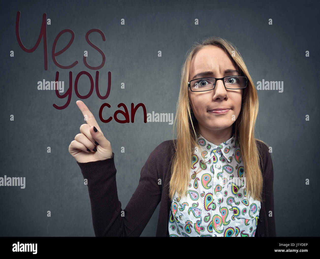 Schoolgirl nerd pointing at a Yes you can sign Stock Photo