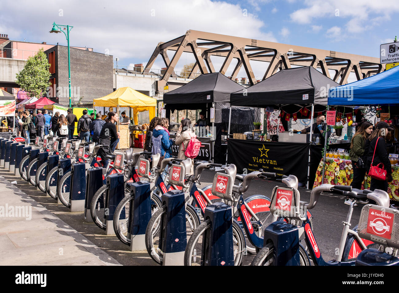 Street view of Brick Lane Market with people and food stalls next to a ...