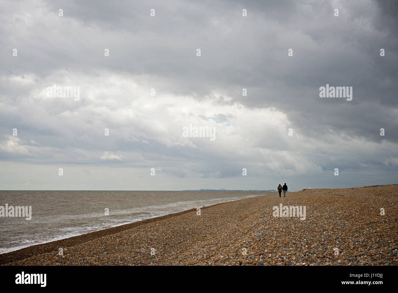 Couple walking on Shingle Beach, Orford Ness, Suffolk, England UK Stock Photo